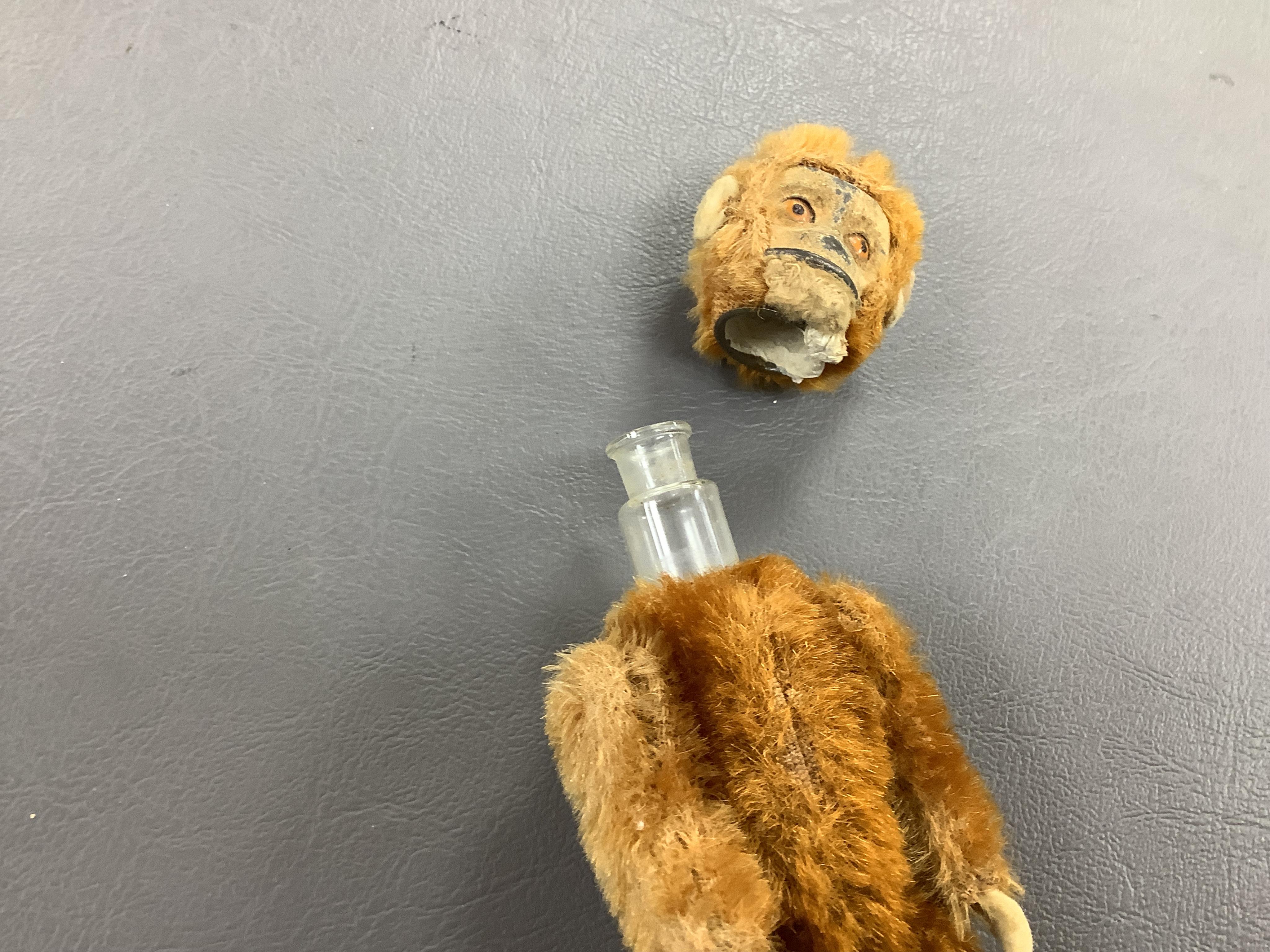 A German Schuco scent bottle monkey, with mohair body containing a glass bottle, together with a white metal Japanese style lid box decorated with a floral landscape and bird of prey to the lid